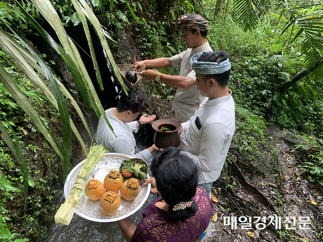 아비세나 우붓의 ‘로컬체험 모닝워크’ 체험을 하는 모습. 리조트 투숙객이 발리 전통 의식을 경험하고 있다. [사진 = 김민주 기자]