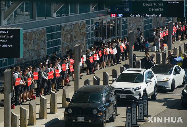 [밴쿠버=신화/뉴시스] 11일(현지 시간) 캐나다 브리티시컬럼비아주 리치먼드 밴쿠버 국제공항에서 에어캐나다 승무원들이 전국 행동의 날을 맞아 침묵시위를 하고 있다.   2025.08.14.