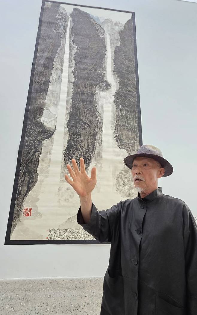 [사진=박현주 미술전문기자] 14일 대구 리안갤러리에서 열린 개인전 ‘화여기인’에 선보인 ‘폭포’ 작품 앞에서 박대성 화백이 그림 아래 적힌 한글 시구에 대해 설명하고 있다. *재판매 및 DB 금지