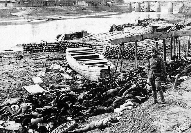 ‘도살’ - 1937년 12월 중국 난징 친화이 강변에 아무렇게나 버려진 민간인 시체들 옆으로 일본 군인이 지나가고 있다. 작가 무라세 모리야스(1909~1988) 사진집