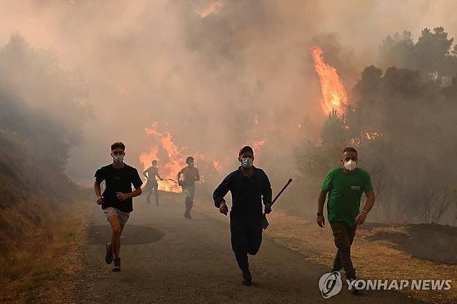 스페인 북서부 오우렌세에서 산불을 피해 달아나는 주민들  [AFP 연합뉴스 자료사진 재판매 및 DB 금지]