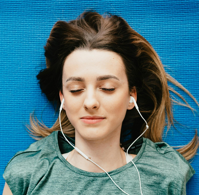 이어폰을 끼고 누워있는 사람