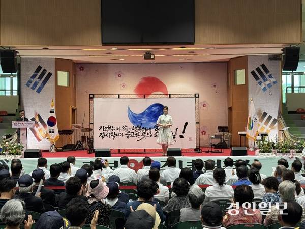 이화선 작가가 완성된 태극기 캘리그라피 작품 앞에서 퍼포먼스를 마친 후 관객들에게 인사하고 있다. ‘기억합니다. 오늘의 이 행복 뒤에 헌신’, ‘감사합니다. 숭고한 뜻으로 되찾은 빛!’이라는 메시지가 돋보인다. 2025.5.18 여주/양동민기자 coa007@kyeongin.com