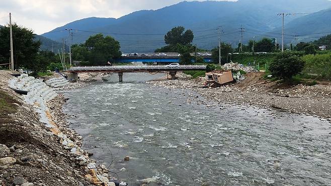 ▲ 지난 7월 집중호우로 포천시 내촌면 왕숙천에 떠내려온 콘테이너가 여전히 방치돼 있다.