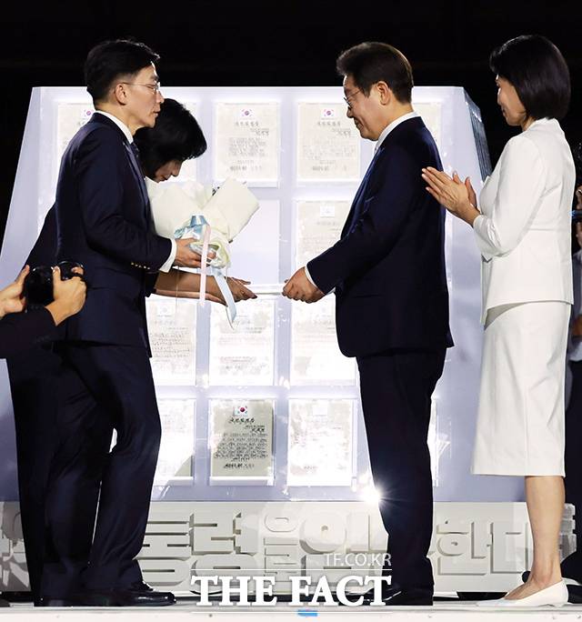 이재명 대통령이 15일 서울 세종대로 광화문광장에서 열린 제21대 대통령 국민임명식 '광복 80년, 국민주권으로 미래를 세우다' 행사에서 이국종 국군대전병원장, 이연수 NC AI 대표로부터 임명장을 받고 있다. /뉴시스
