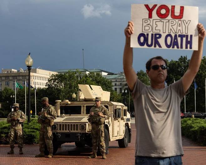워싱턴DC에 배치된 주방위군 앞에서 시위를 하는 시민. EPA·연합뉴스