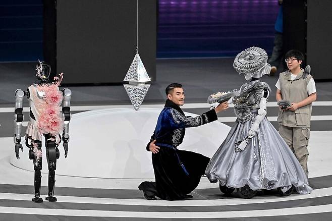 15일(현지시각) 한 공연자가 로봇과 함께 연기를 하고 있다. 베이징/AFP 연합뉴스