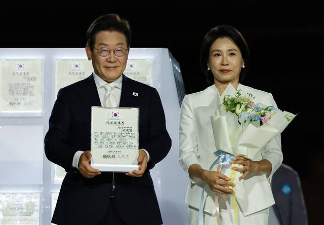 이재명 대통령과 김혜경 여사가 15일 서울 광화문광장에서 열린 제21대 대통령 국민임명식 ‘광복 80년, 국민주권으로 미래를 세우다’ 행사에서 국민 대표 80인으로부터 ‘빛의 임명장’을 받고 있다. 대통령실사진기자단