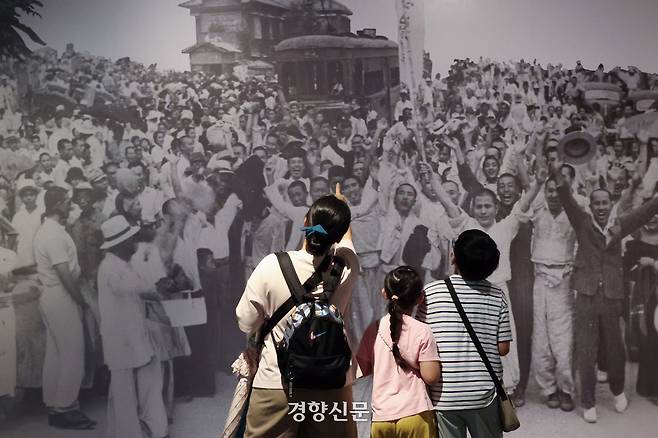 광복절 80주년을 하루 앞둔 14일 서울 종로구 서울역사박물관을 찾은 한 가족이 ‘우리들의 광복절’ 특별전은 관람하고 있다. 전시된 사진은 광복 다음날인 1945년8우러16일 오전 서울 서대문구 서대문형무소에서 석방된 독립운동가들이 군중과 함께 만세를 외치는 장면이다. 한수빈 기자 subinhann@kyunghyang.com