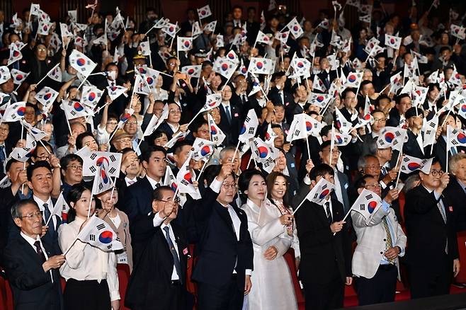 이재명 대통령이 15일 서울 세종문화회관에서 진행된 제80주년 광복절 경축식에서 참석자들과 태극기를 흔들며 만세삼창을 하고 있다. 앞줄 왼쪽부터 강민지 독립유공자 후손, 이종찬 광복회장, 이 대통령, 김혜경 여사, 권인혁 독립유공자 후손. 김호영 기자