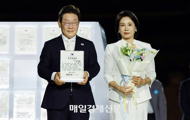 이재명 대통령과 김혜경 여사가 15일 서울 세종대로 광화문광장에서 열린 제21대 대통령 국민임명식 ‘광복 80년, 국민주권으로 미래를 세우다’ 행사에서 국민 대표 80인으로부터 ‘빛의 임명장’을 받은 뒤 감사 인사를 하고 있다. 2025.8.15 김호영기자