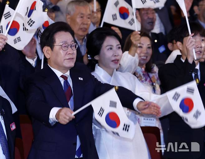 [서울=뉴시스] 최동준 기자 = 이재명 대통령과 김혜경 여사가 15일 서울 종로구 세종문화회관에서 열린 제80주년 광복절 경축식에서 참석자들과 태극기를 흔들고 있다. 2025.08.15. photocdj@newsis.com