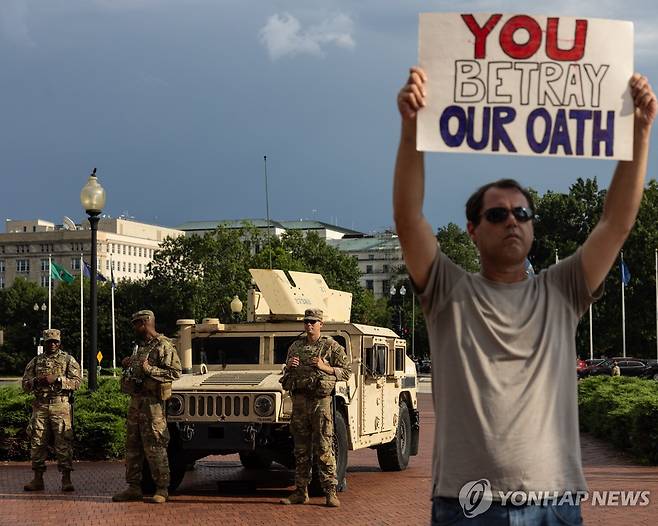 워싱턴DC에 배치된 주방위군 앞에서 시위를 하는 시민 [EPA 연합뉴스 자료사진]