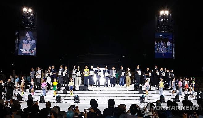 대통령 국민임명식, 80인의 대표들 (서울=연합뉴스) 홍해인 기자 = 15일 서울 광화문광장에서 열린 제21대 대통령 국민임명식 행사에서 80인의 국민대표들이 무대에 올라와 있다. 2025.8.15 hihong@yna.co.kr