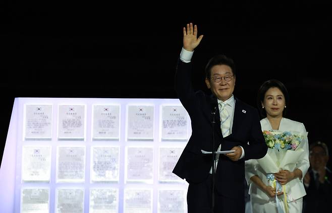이재명 대통령과 김혜경 여사가 15일 서울 세종대로 광화문광장에서 열린 제21대 대통령 국민임명식 '광복 80년, 국민주권으로 미래를 세우다' 행사에서 국민 대표 80인으로부터 '빛의 임명장'을 받은 뒤 감사 인사를 하고 있다. 사진=연합뉴스