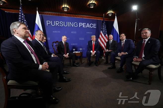 15일(현지시간) 미국 알래스카 앵커리지의 엘멘도르프-리처드슨 합동기지에서 만난 도널드 트럼프 미국 대통령(오른쪽에서 네번째)과 블라디미르 푸틴 러시아 대통령(오른쪽에서 다섯번째)을 비롯해 양국 참석자들 우크라이나 전쟁 종식을 위한 회담에 앞서 사진 촬영에 응하고 있다. 러시아에서는 (사진 맨 왼쪽부터) 유리 우샤코프 크렘린궁 외교보좌관, 세르게이 라브로프 러시아 외무장관이 배석했고, 미국 측에서는 (사진 오른쪽부터) 스티브 위트코프 미 트럼프 대통령 특사, 마코 루비오 미 국무장관이 자리했다. 양국 정상 바로 옆에는 통역사가 앉았다. 2025.08.15. ⓒ AFP=뉴스1 ⓒ News1 류정민 특파원