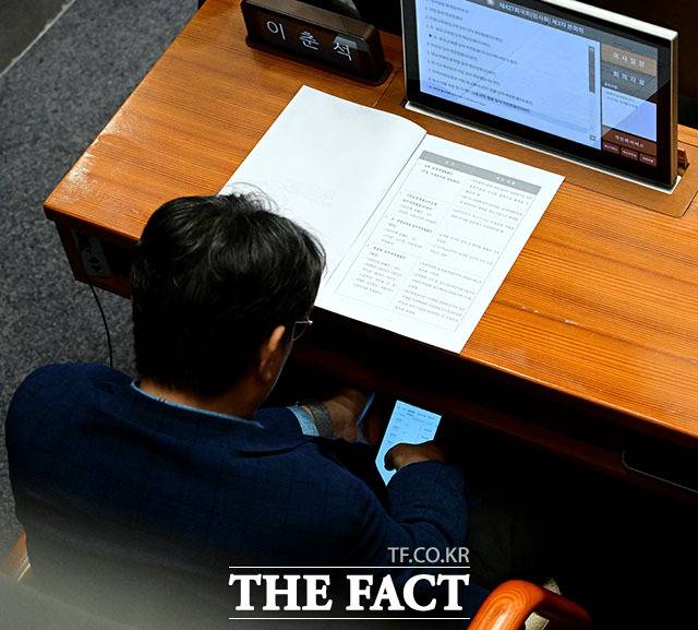 미공개 정보를 이용해 주식을 차명으로 거래한 혐의를 받는 이춘석 무소속 의원이 경찰 조사에서 혐의 일부를 인정한 것으로 전해졌다. 사진은 이춘석 의원이 지난 4일 서울 여의도 국회에서 열린 본회의에서 보좌관 차 씨 명의로 개설된 주식 계좌를 확인하고 있는 모습./남윤호 기자