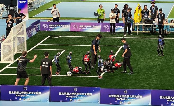15일 중국 베이징 국가스피드스케이팅홀에서 열린 '세계 휴머노이드 로봇 운동회'에 참가한 로봇들이 5대5 축구시합을 하고 있다./연합뉴스