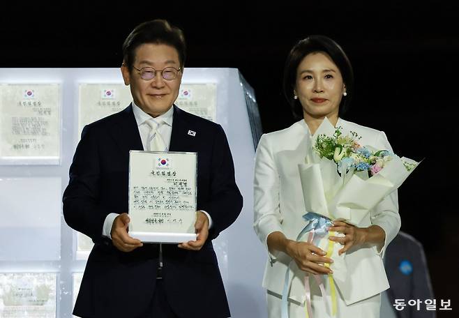 이재명 대통령과 김혜경 여사가 15일 서울 광화문광장에서 열린 제21대 대통령 국민임명식에서 국민 대표 80인으로부터 ‘빛의 임명장’을 받은 뒤 기념 촬영을 하고 있다.
송은석 기자 silverstone@donga.com