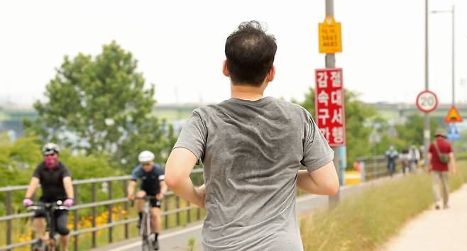 서울 잠원한강공원에서 한 시민이 뛰면서 운동하고 있다. 연합뉴스