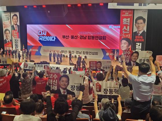 12일 부산에서 열린 국민의힘 전당대회 합동연설회에서 당 대표·최고위원 후보들이 연단에 오르자 응원 팻말과 현수막을 든 당원들이 일어나 후보자 이름을 연호하고 있다. 신수민 기자