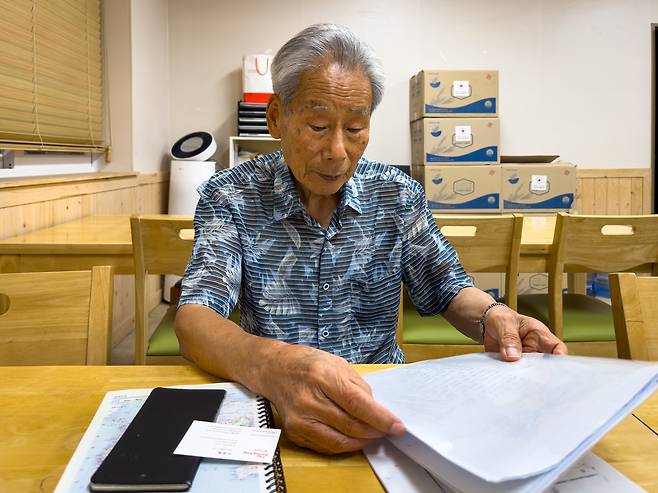 Kim Chul-soo, an 87-year-old Korean survivor of the atomic bombing of Hiroshima, looks through his family records during an interview with the Korea JoongAng Daily in Hapcheon, South Gyeongsang, on Aug. 12. [MICHAEL LEE]