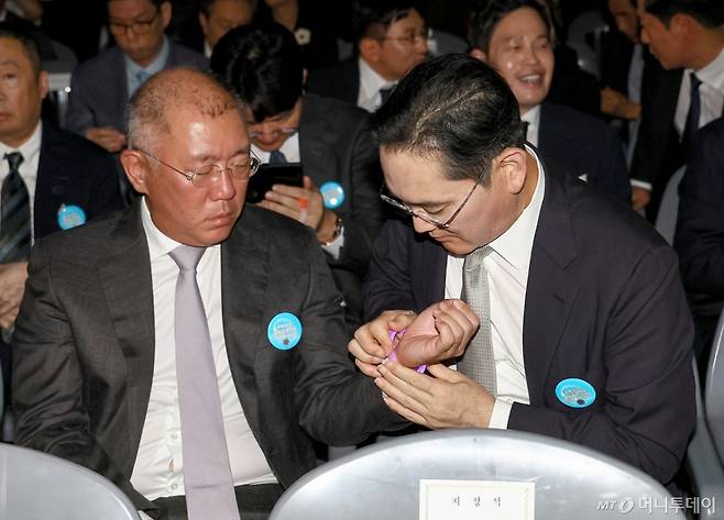 [서울=뉴시스] 고범준 기자 = 15일 서울 세종대로 광화문광장에서 열린 제21대 대통령 국민임명식 '광복 80년, 국민주권으로 미래를 세우다' 행사에서 이재용 삼성전자 회장이 정의선 현대차그룹 회장에게 야광팔찌를 채워주고 있다. 2025.08.15. bjko@newsis.com /사진=