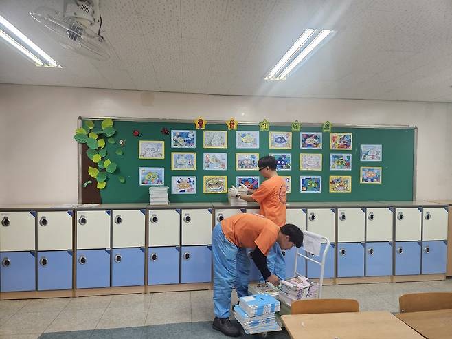 용역 인력이 각 반별로 교과서를 운반해 배부하고 있다