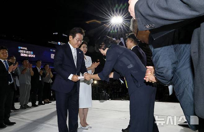 이재명 대통령이 2025년 8월 15일 서울 세종대로 광화문광장에서 열린 제21대 대통령 국민임명식 ‘광복 80년, 국민주권으로 미래를 세우다’ 행사에서 이연수 NC AI 대표로부터 임명장을 받고 있다. 사진=뉴시스