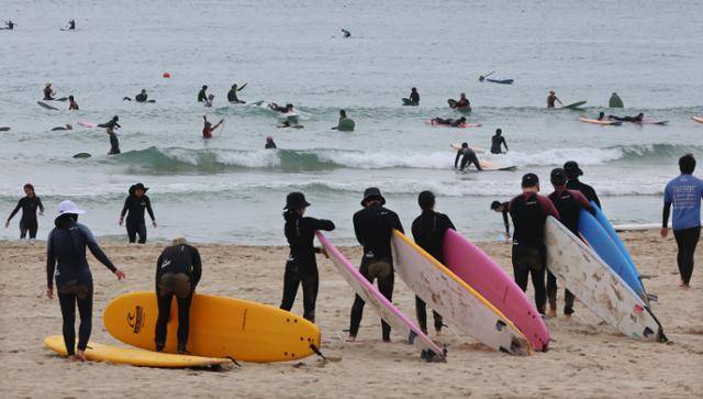 11일 부산 해운대구 송정해수욕장에서 시민들이 서핑을 즐기고 있다. 연합뉴스