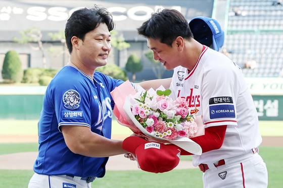 지난 7일 SSG와의 원정 경기에서 후배 김광현(오른쪽)으로부터 꽃다발을 받는 오승환. 뉴스1