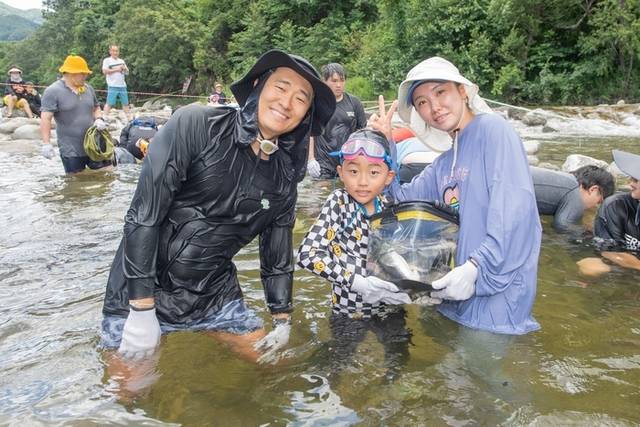 ▲ 가족 방문객들이 소똥령 유원지에서 메기를 잡은 후 기념포즈를 취했다.