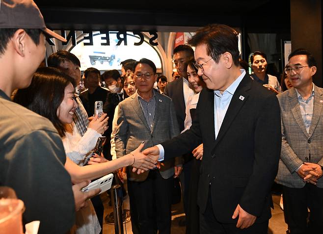 이재명 대통령이 17일 서울 용산 아이파크몰 CGV 영화관에서 영화 <독립군:끝나지 않은 전쟁>을 관람한 뒤 극장을 나가며 시민들과 인사하고 있다.  대통령실사진기자단