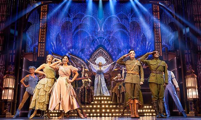 브로드웨이 오리지널 팀이 선보이는 뮤지컬 ‘위대한 개츠비’는 재즈 시대의 황홀과 허무, 사랑과 계급의 충돌을 대극장 스케일과 섬세한 넘버로 그려낸다. 역대급 무대로 기록될 뮤지컬 ‘위대한 개츠비’는 대표적 부촌인 롱아일랜드 저택가의 호화로움과 대비하는 어둑한 접경지대의 주유소, 브루클린 브리지 하부를 연상시키는 거리 장면이 고해상도 LED배경과 다단 백월, 이동식 구성물로 겹겹이 구축된다. 사진은 개츠비의 대저택에서 진행 중인 파티의 한 장면. 오디컴퍼니 제공