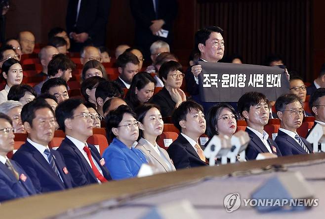 사면 반대 펼침막 든 안철수 의원 (서울=연합뉴스) 홍해인 기자 = 국민의힘 안철수 의원이 15일 서울 세종문화회관에서 열린 80주년 광복절 경축식에서 이재명 대통령이 경축사를 마치고 자리로 향할 때 '조국·윤미향 사면 반대'라는 문구가 적힌 펼침막을 들어보이고 있다. 2025.8.15 [대통령실통신사진기자단] hihong@yna.co.kr