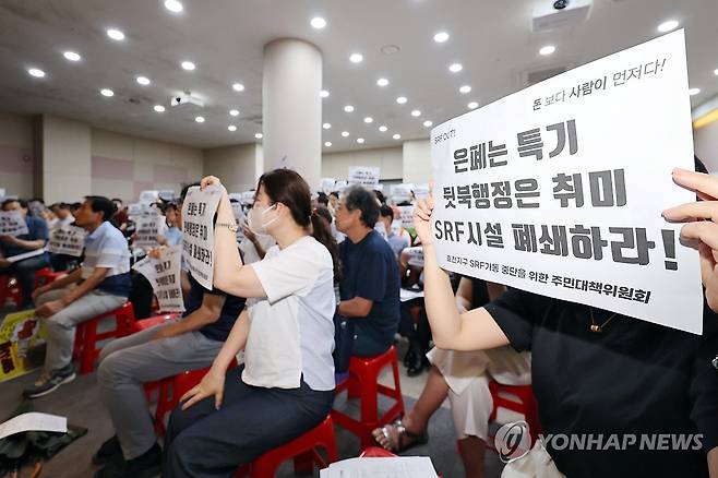 항의하는 광주 효천지구 주민들 (광주=연합뉴스) 정다움 기자 = 14일 오전 광주 남구 양과동 광역위생 매립장 내 가연성폐기물 연료화시설(SRF)에서 열린 악취 해결을 위한 간담회에서 주민들이 손팻말을 들고 구호를 외치고 있다. 2025.8.14 daum@yna.co.kr