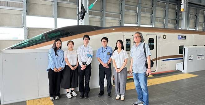 공동취재단이 JR서일본 카나자와 지사 관계자들과 호쿠리쿠 신칸센 앞에서 기념 촬영을 하고 있다.