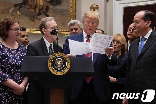 도널드 트럼프 미국 대통령이 9일(현지시간) 워싱턴 백악관에서 열린 '엄청난 의료비 청구서 종료 선언' 행사 중 의료비 청구서룰 보고 있다. ⓒ AFP=뉴스1 ⓒ News1 우동명 기자