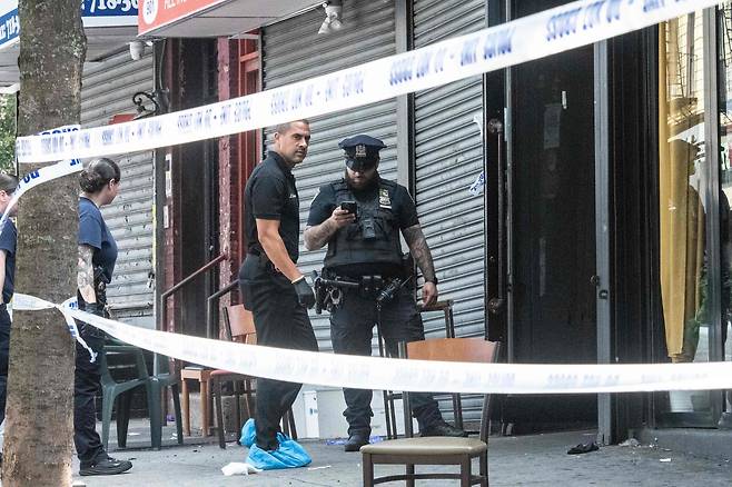 뉴욕경찰(NYPD) 소속 대원들이 17일 뉴욕 브루클린 크라운 하이츠에 있는 테이스트 오브 더 시티 라운지에서 발생한 총격 사건을 조사하고 있다. /연합뉴스