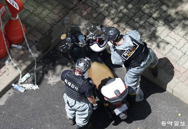 17일 오전 서울 마포구 창전동 삼성아파트 14층에 화재가 발생, 모자 관계의 남녀 2명이 숨지고 13명이 부상했다. 이날 오후 소방관들이 1층에 있던 오토바이를 조사하고 있다. 변영욱 기자 cut@donga.com