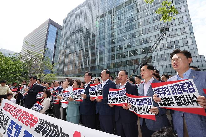 국민의힘 송언석 비대위원장 겸 원내대표 등 의원들이 18일 김건희 여사 관련 의혹을 수사하는 민중기 특별검사팀 사무실이 마련된 서울 종로구 KT 광화문빌딩 웨스트 앞에서 현장 비상의원총회를 열고 구호를 외치고 있다. [연합뉴스]