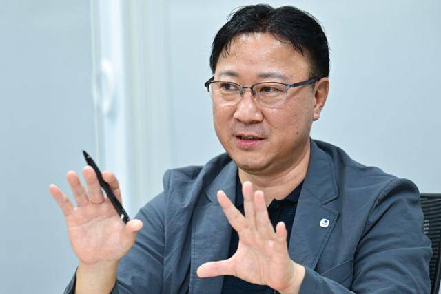 장윤완 우리은행 여신관리부 채무조정팀장이 13일 서울 중구 우리은행 사무실에서 본보와 인터뷰하고 있다. 사무실 한편에 걸린 '채무조정도 영업이다'라는 문구가 적힌 커다란 플래카드에서, 채무조정도 상품 판매처럼 끈질기게 임하자는 각오가 엿보인다. 강예진 기자