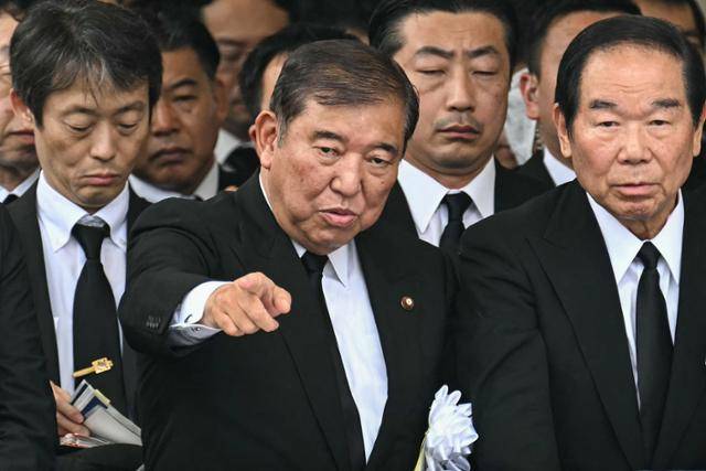 이시바 시게루(앞줄 가운데) 일본 총리가 9일 나가사키현 나가사키시 평화공원에서 열린 원폭투하 전몰자 위령식에서 손가락으로 앞을 가리키고 있다. 나가사키=AFP 연합뉴스