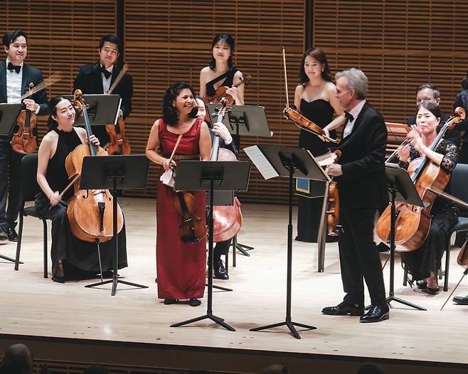 Violinists Adele Anthony (left) and Gil Shaham receive applause on stage with Sejong Soloists at Carnegie Hall in New York City on April 8. (Sejong Soloists)