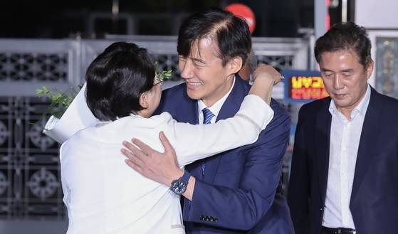 Cho Kuk, center, former leader of the Rebuilding Korea Party, embraces acting party leader Kim Sun-min after being released from the Seoul Southern Detention Center in Seoul on Aug. 15 under a special Liberation Day pardon and reinstatement. [JUN MIN-KYU]