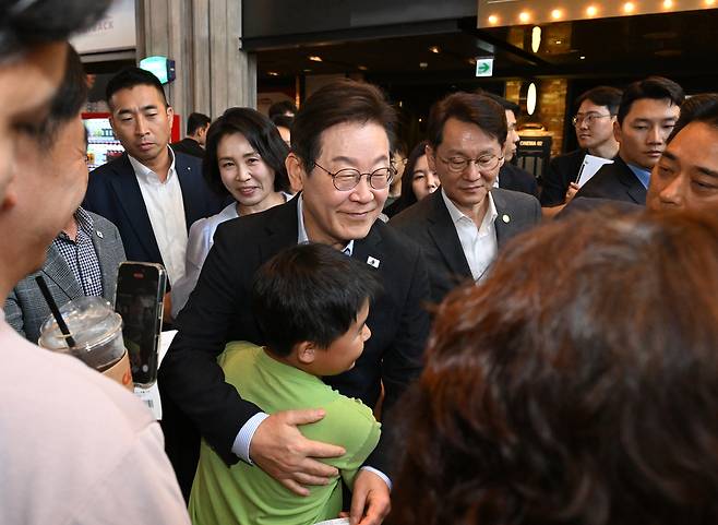 이재명 대통령이 17일 서울 용산CGV에서 ‘독립군:끝나지 않은 전쟁’ 관람 후 한 어린이와 포옹하고 있다. 연합뉴스