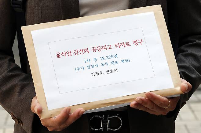 18일 법률사무소 호인의 관계자가 서울 서초구 서울중앙지방법원에서&nbsp;윤석열&nbsp;전 대통령 부부를 상대로 한 12·3 비상계엄 관련 손해배상소송 서류를 들고 있다. ⓒ연합뉴스