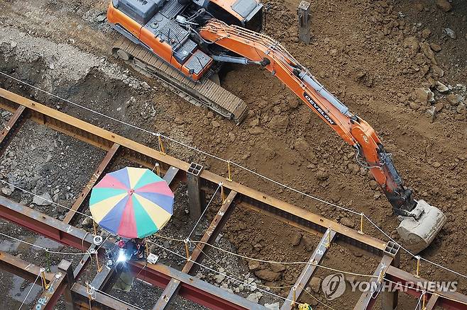 '폭염 속 파라솔 아래 작업' [연합뉴스 자료사진]