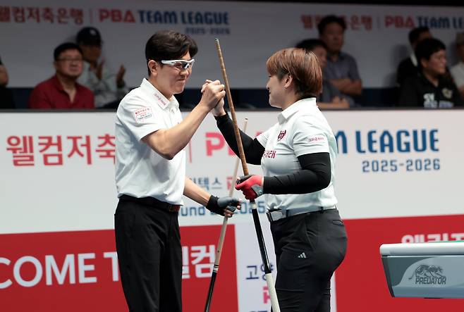 크라운해태 김재근과 히가시우치 나쓰미가 승리 후 두 손을 맞잡고 있다. 사진제공=PBA