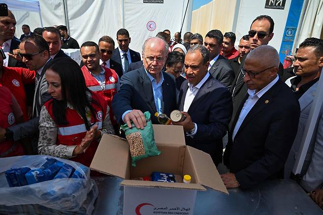 팔레스타인 총리 모하마드 무스타파(가운데)가 이집트 외무장관 바드르 압델라티(가운데 오른쪽)와 함께 2025년 8월 18일 엘아리시에 있는 가자지구에 대한 인도적 지원을 준비하는 구호단체 창고를 방문하고 있다. /연합뉴스